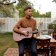 young man sits at the table and plays the guitar - PhotoDune Item for Sale