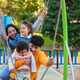 Hispanic family with two children playing together in a playground. - PhotoDune Item for Sale