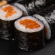 Maki sushi roll with salmon avocado and tobiko caviar served on black board close-up - Japanese food - PhotoDune Item for Sale