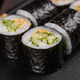 Maki sushi roll with cucumber and sesame with chopsticks close-up. Sushi menu. Japanese food. - PhotoDune Item for Sale