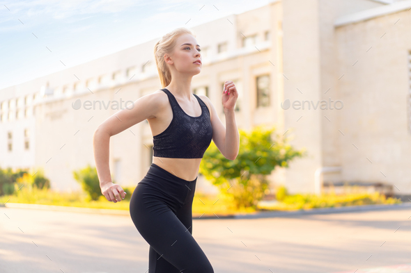Sport and Fitness. Fit Woman Running City Street Summer Sunny Morning  Caucasian Athletic Female Stock Photo by andreonegin