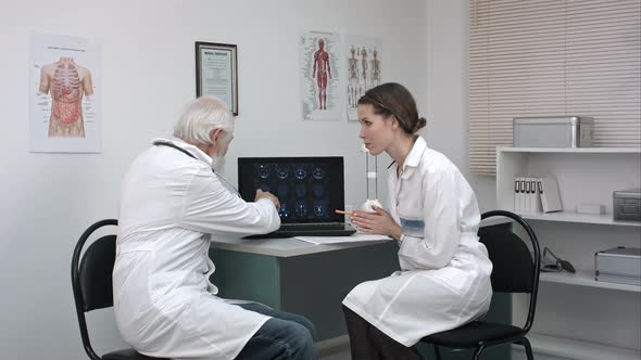 Medical Doctors at Laptop Computer Discussing Patient's Scans.