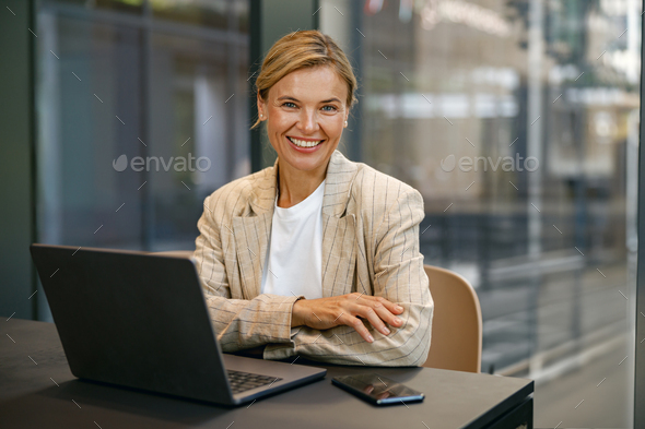 Pretty business woman working on laptop sitting the desk on office