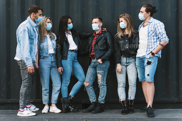 Group of friends wearing prevention masks during their meeting outdoors.