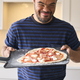 Man With Down Syndrome At Home With Homemade Pizza Ready To Bake In Kitchen - PhotoDune Item for Sale