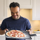 Man With Down Syndrome At Home With Homemade Pizza Ready To Bake In Kitchen - PhotoDune Item for Sale