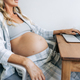Unrecognizable pregnant woman working at home online. - PhotoDune Item for Sale