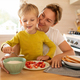 lifestyle concept, young mother and son sitting at the table in the kitchen with plates of food - PhotoDune Item for Sale
