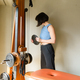 Caucasian woman at home standing next to her training machine with dumbbell in her hand - PhotoDune Item for Sale