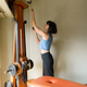 Caucasian adult woman at home arranging pulleys of her training machine - PhotoDune Item for Sale