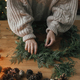Making Christmas rustic wreath. Hands holding cedar branches, making wreath on wooden table - PhotoDune Item for Sale