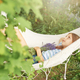 A little girl rests in a hammock  in the summer. - PhotoDune Item for Sale