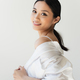 Pretty asian woman adjusting white shirt and smiling at camera isolated on grey - PhotoDune Item for Sale