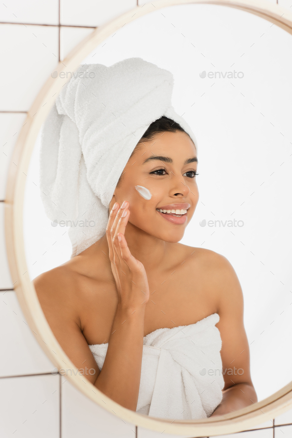 Portrait of young african american woman wrapped in towels sitting