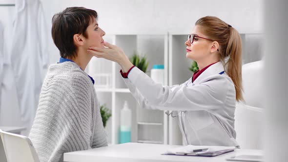 Woman Doctor Oncologist in Uniform Examining Patient Touching Female Neck and Head Medium Closeup alt
