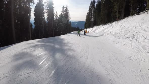 Slide Down on Ski Slope at Ski Resort. POV View on Skiers and Snowboarders alt