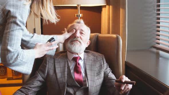 Makeup Artist Corrects Makeup on the Face of an Elderly Actor. alt