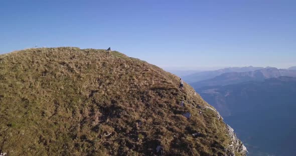 Panoramic view of a huge mountain ridge in Switzerland while fall. A young hiker runs up and stumble alt