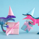 Cute dinosaurs with gift boxes and party hats on blue background. Cute minimal birthday concept. - PhotoDune Item for Sale