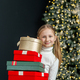 Preteen child with gift boxes in room. Concept New Year, Merry Christmas, holiday, vacation, winter - PhotoDune Item for Sale