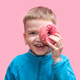 funny boy in a blue sweater holds a bright pink donut near his eye and laughs on a pink background. - PhotoDune Item for Sale