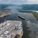 aerial view of a container ship is seen assisted by two tugboats as it departs the harbor - PhotoDune Item for Sale