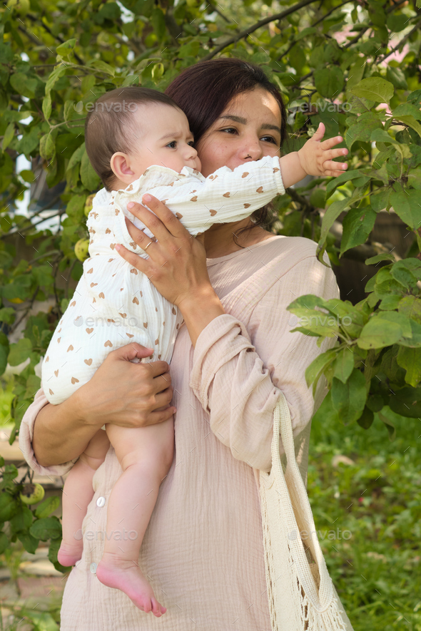 Embodying the essence of health and vitality, a mother holds her one-year-old with love, surrounded