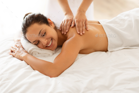 Body care. Relaxed woman enjoying back massage Stock Photo by