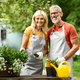 Portrait Of Smiling Senior Couple Planting Flowers Together Their In Garden - PhotoDune Item for Sale