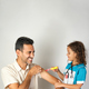 little girl dressed as a nurse playing doctor with her father with a toy syringe - PhotoDune Item for Sale