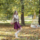 young girl with long blond hair in an autumn park with string bag with red apples - PhotoDune Item for Sale