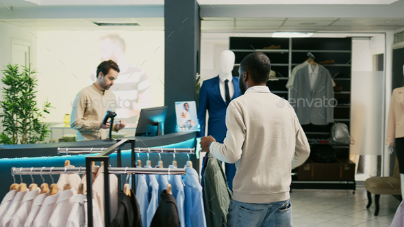 Male shopper buying formal or casual wear in boutique