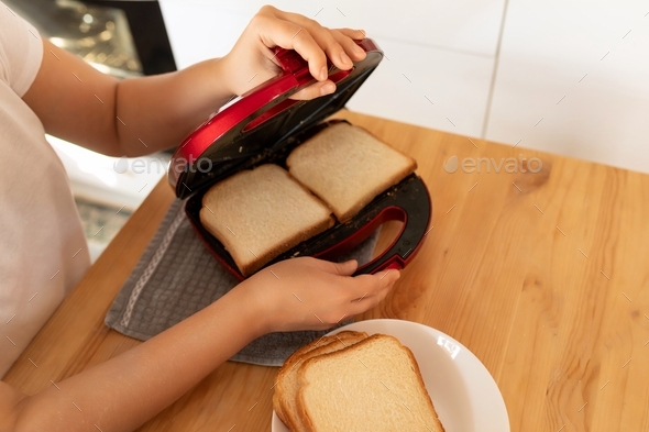a woman is going to make toast in the toaster oven in the kitchen