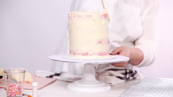 Step by step. Icing tall birthday cake with white buttercream icing. alt