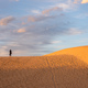 Landscape shot of woman standing on sand dune - PhotoDune Item for Sale