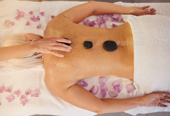 Woman, spa and above of stone massage for skincare treatment, holistic physical therapy and healing