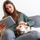 Woman reading an ebook and cuddling her dog - PhotoDune Item for Sale