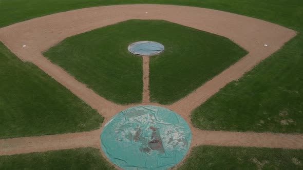 Panoramic view of ball field groomed at the end of the day. Swirls in dirt. Worn grass.