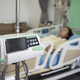 Middle-aged Asian female patient recovering from illness in hospital room, health care concept. - PhotoDune Item for Sale