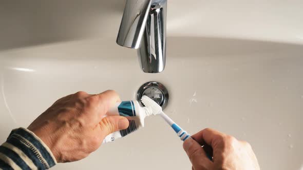 Squeezing Toothpaste From a Tube on a Toothbrush