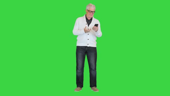 Satisfied Old Man Using His Smartphone on a Green Screen Chroma Key alt