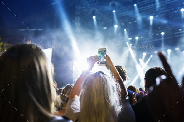 Woman filming concert with her smartphone