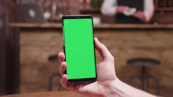 Parallax Dynamic Slide Shot of Male Hands Holding a Modern Phone with Green Screen on alt