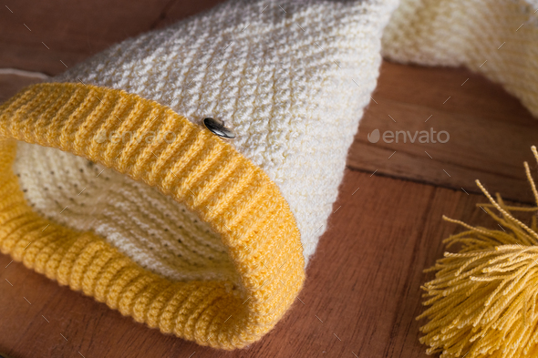 two rolls of yellow and white yarn to crochet, on a black and orange wooden  background. Stock Photo by mauriciotoro10