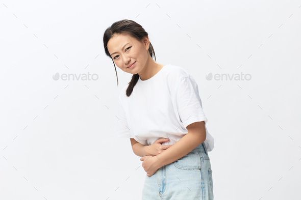 Stomach ulcer Gastritis. Tormented suffering tanned beautiful young Asian woman hugs herself hold