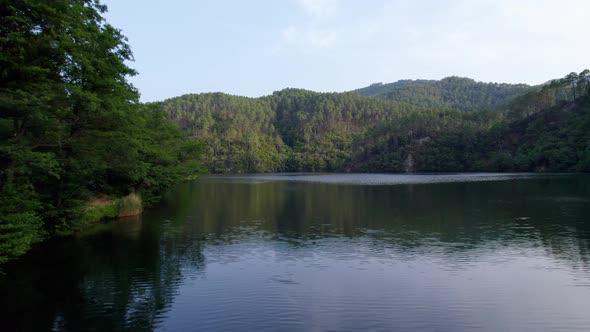 Calm waters of lake Cambous in Branoux-les-Taillades France, Aerial low angle shot alt