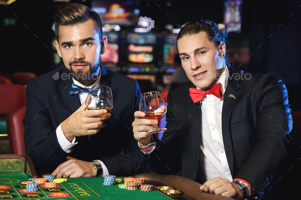 Rich and handsome guys drinking cognac and playing roulette in the casino