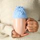 Knitted blue cap on cup in female hands on gray backgroundKnitted blue cap on cup in female hands - PhotoDune Item for Sale