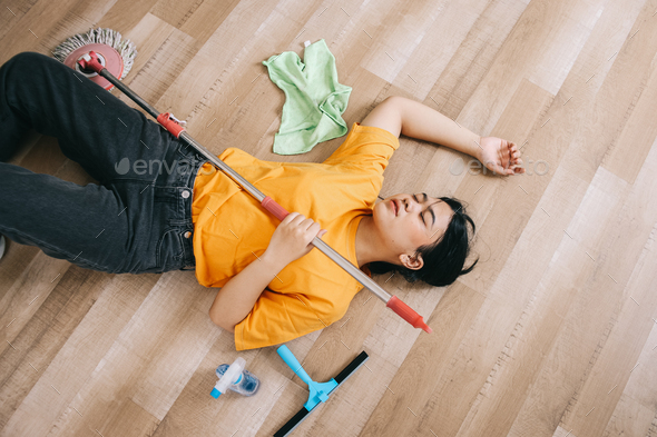 Exhausted Woman Laying on The Floor Tired After Cleaning