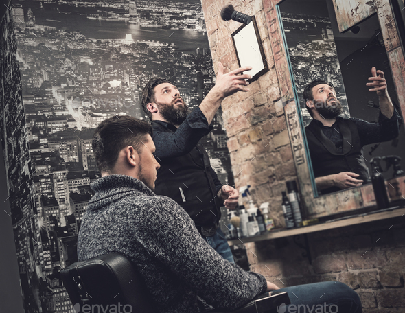 Barber during his work with client in his studio